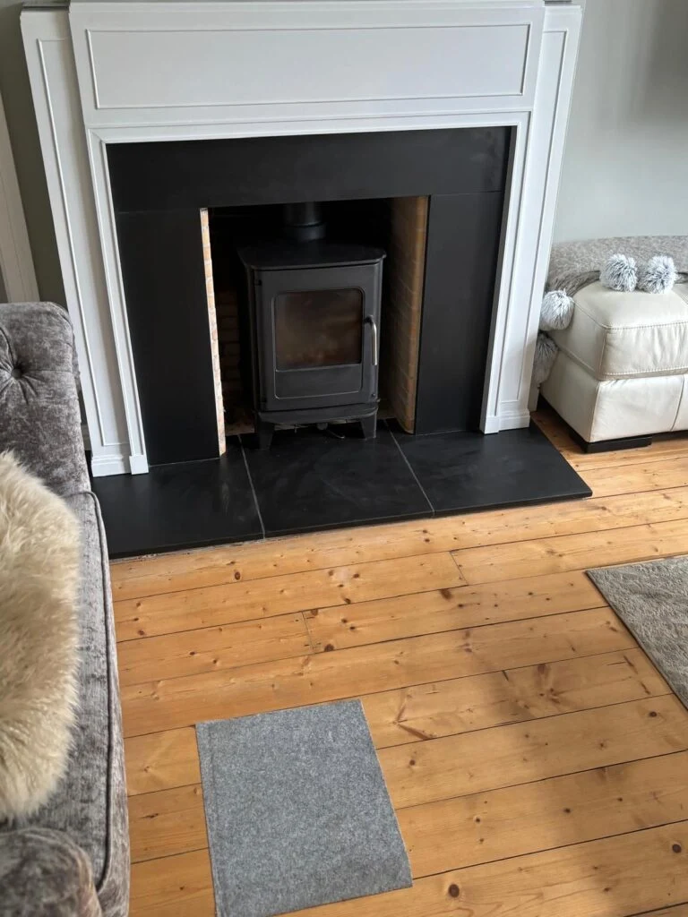Stove and black hearth beneath a white mantel